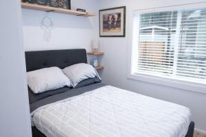 a bedroom with a bed with a window and a white bedspread at Cozy 2 Bedroom Cabin in Sunshine Valley