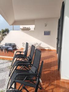 a row of black chairs sitting on a patio at AFRODITE in Porto Cesareo