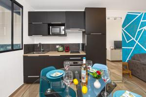 a kitchen with a table and chairs with wine glasses at Vue mer port de garavan in Menton