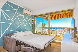 a bedroom with a bed and a view of the ocean at Vue mer port de garavan in Menton +14 photos