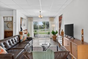 a living room with a couch and a flat screen tv at Sixty at Yellow Doors in Goolwa South
