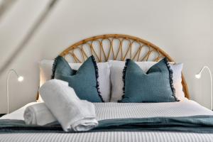 a bedroom with a bed with blue and white pillows at Sixty at Yellow Doors in Goolwa South