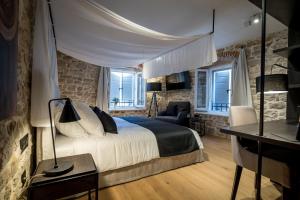 um quarto com uma cama e uma secretária com um candeeiro em Murum Heritage Hotel em Split