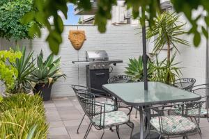 a patio with a table and chairs and a grill at Sixty at Yellow Doors in Goolwa South +13 photos