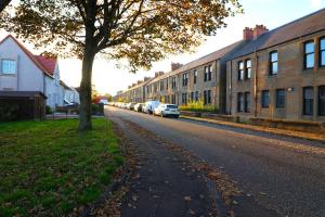 a street with cars parked on the side of the road at Modern 2 Bedroom Cottage Flat in Stenhousemuir
