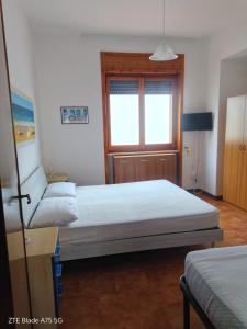 a bedroom with two beds and a window at AFRODITE in Porto Cesareo