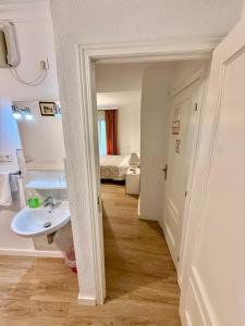 a hallway with a sink and a bathroom with a bed at Pension Zurita in Granada +56 photos