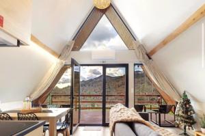 a living room with a large window with a mountain view at Chalés Luna In Rio Chalé Rio in Ponte da Barca