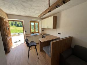 a kitchen with a table and a chair in a room at Ferienwohnung Almzeit in Gressenberg