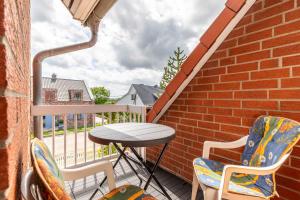 a balcony with a table and chairs on a brick wall at Ferienwohnung Tina OG in Boltenhagen