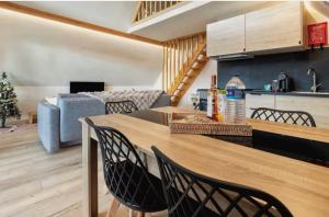 a kitchen and living room with a wooden table and chairs at Chalés Luna In Rio Chalé Rio in Ponte da Barca