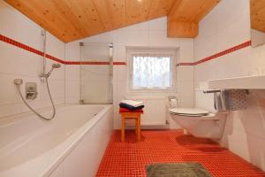 a bathroom with a tub and a toilet and a sink at Rundblick Gästehaus Schruns Tschagguns by Alpenfeder in Schruns +34 photos