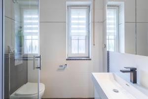 a white bathroom with a toilet and a sink at Ferienwohnung Tina EG in Boltenhagen