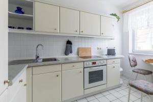 a kitchen with white cabinets and a sink at Ferienwohnung Tina EG in Boltenhagen