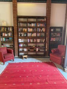 a living room with two chairs and a red rug at Bronlara in Alhaurín de la Torre