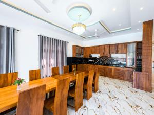 a dining room with a wooden table and chairs at Omar Villa in Bentota