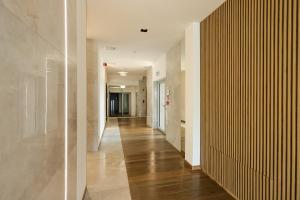 ein Flur mit Holzboden und weißen Wänden in der Unterkunft Poznań West Hotel - Airport in Posen