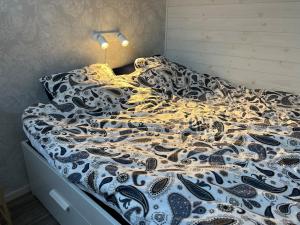 a bed with a black and white comforter at house with sea view in Varberg