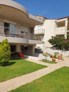 a large house with a balcony and a yard at Εξοχικό Σταμάτη in Lóngos