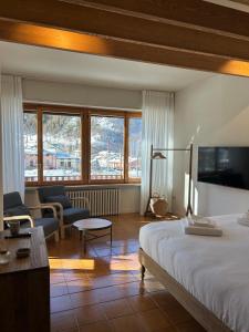 a bedroom with a bed and a living room at B&B Il Faggio Rosso in Vernante