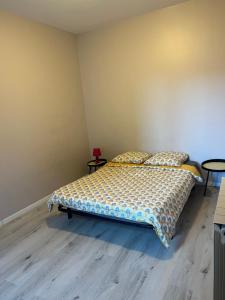 a bedroom with a bed and two tables in it at Appartement Millau climatisé in Millau