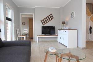 a living room with a couch and a glass table at Ferienhaus Skanhuus in Klütz