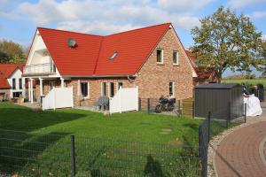a large brick house with a red roof at Ferienhaus Skanhuus in Klütz