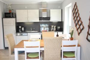 a kitchen and dining room with a wooden table and chairs at Ferienhaus Skanhuus in Klütz