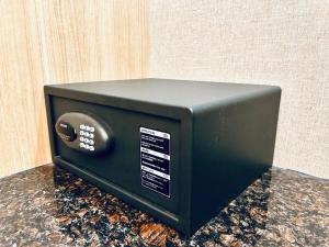 a black microwave oven sitting on top of a counter at Orchardz Jayakarta in Jakarta
