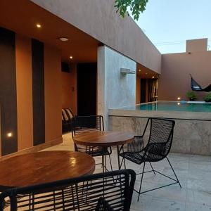 a patio with tables and chairs and a bar at Casa Josefina in Hunucmá