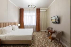 a hotel room with a bed and a table and a chair at Boutique Hotel Tomiris in Astana
