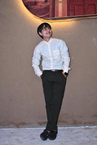 a young man standing in front of a wall at VVIP Gajban Resort & Desert Stay, Bikaner in Bikaner