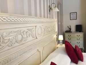 a white bed with red pillows in a bedroom at The Hand at Llanarmon in Llanarmon Dyffryn-Ceiriog