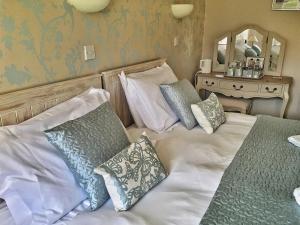a bedroom with two beds with pillows at The Hand at Llanarmon in Llanarmon Dyffryn-Ceiriog +8 photos