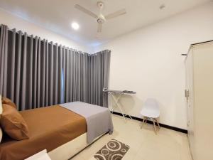 a bedroom with a bed and a curtain at Sea view Apartmen in Trizen in Colombo