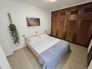 ein Schlafzimmer mit einem großen Bett und Holzschränken in der Unterkunft Simat Malina in Simat de Valldigna + 4 Fotos