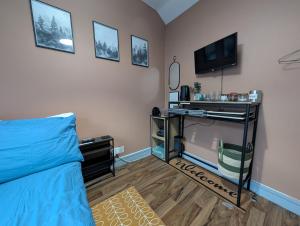a bedroom with a bed and a tv and a tv stand at R3 - Cozy Small Double - City & Beach Access, WIFI, Free Parking, Bus Stop 50ft From House - Self Catering in Swansea