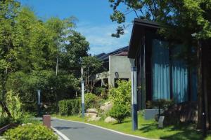 a house on a street with trees and a road at Anji Peiyi Lingfeng Vacation Hotel in Anji