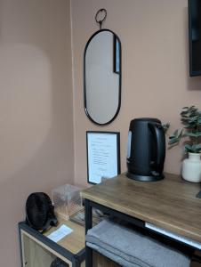 a mirror on the wall above a desk with a television at R3 - Cozy Small Double - City & Beach Access, WIFI, Free Parking, Bus Stop 50ft From House - Self Catering in Swansea