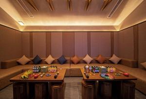 two tables in front of a couch in a restaurant at Anji Peiyi Lingfeng Vacation Hotel in Anji +86 photos