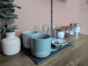 a table with three coffee cups and a vase at R3 - Cozy Small Double - City & Beach Access, WIFI, Free Parking, Bus Stop 50ft From House - Self Catering in Swansea