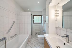 a bathroom with a tub and a toilet and a sink at Lund36 in Husum