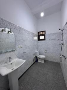 a bathroom with a sink and a toilet at Una Stay in Unawatuna
