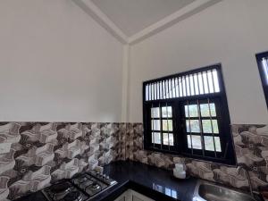 a kitchen with a counter top and a window at Una Stay in Unawatuna