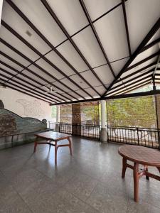 a room with two tables and two benches in it at Una Stay in Unawatuna