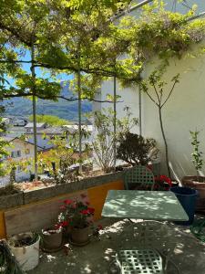 a table and chairs on a balcony with trees at Le Studio du Rhône in Saint-Léonard +1 photo