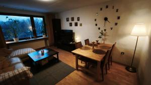 a living room with a table and a living room with a couch at Märchen Apartment in Niestetal
