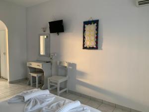 a bedroom with a bed and a desk and a mirror at Melissa Rooms in Koufonisia