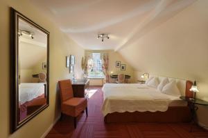 a hotel room with a bed and a mirror at Romantik Hotel Schwan in Horgen +37 photos