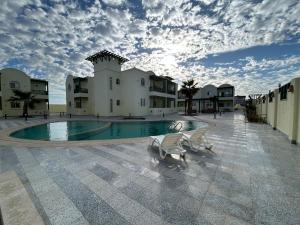 a building with a swimming pool in front of a building at Mazari in Marsa Alam City